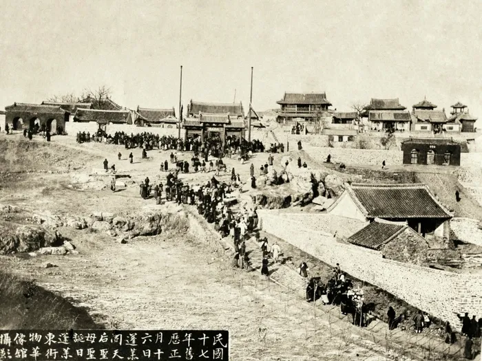 1928年正月十六蓬莱阁天后宫庙会，画面可见丹崖山建筑群、院墙、山道和人群